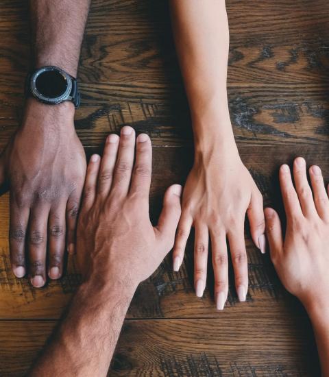 Multiple hands reaching across a table