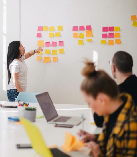 Person pointing at agile workflow on whiteboard